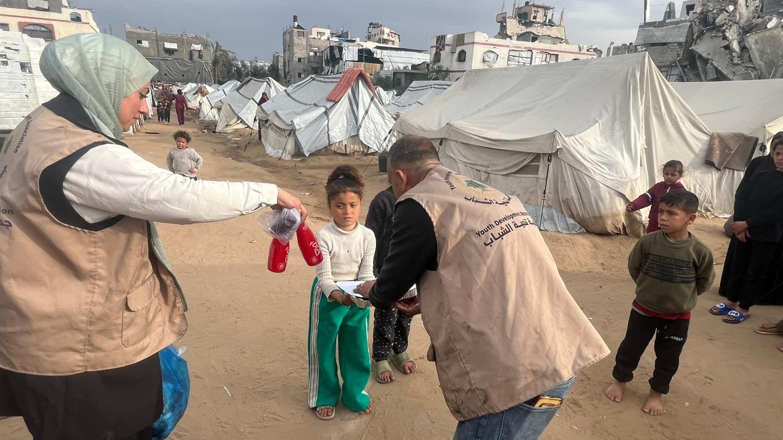 Volunteer handing a food tray to a girl