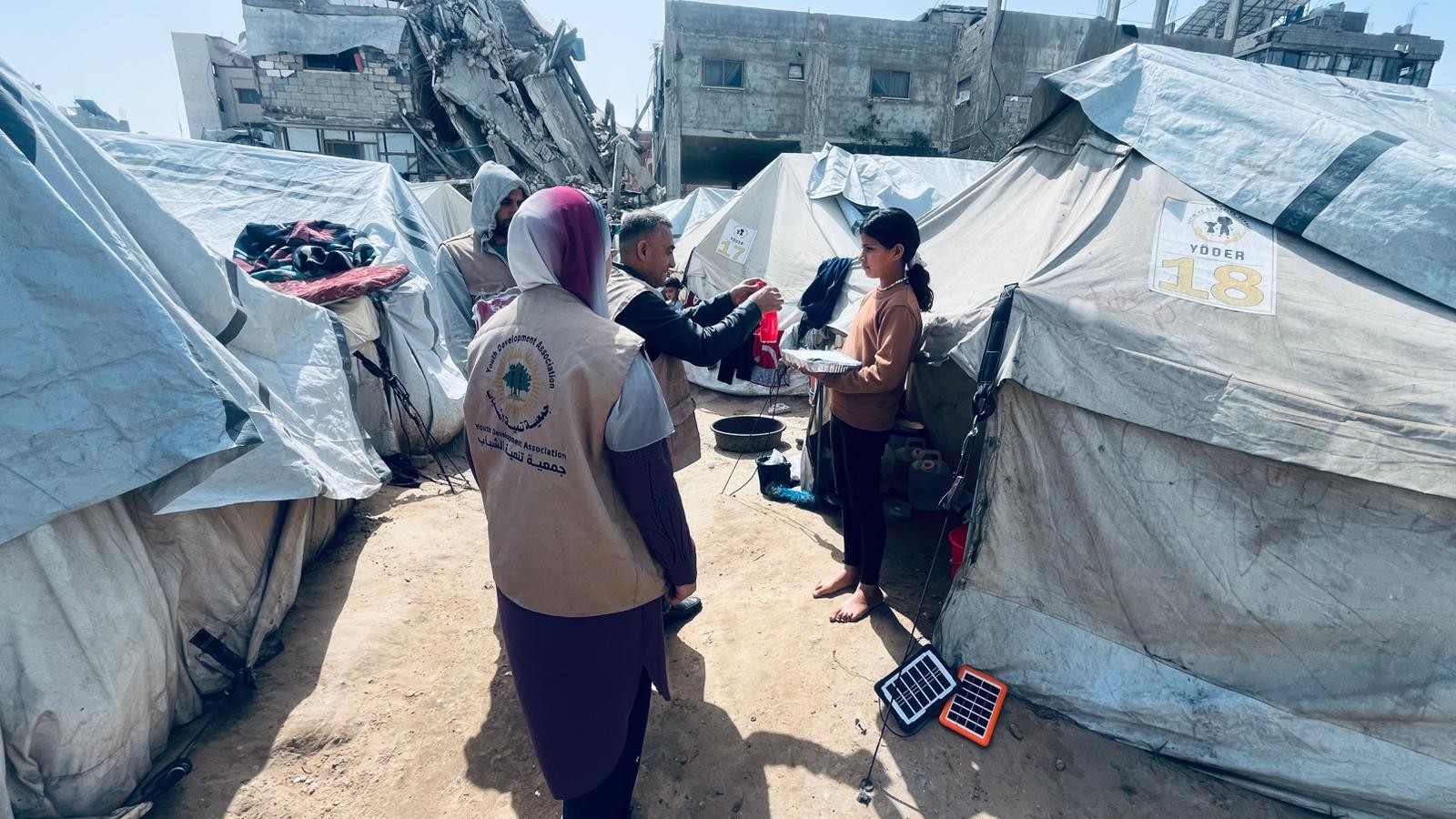 Volunteers carrying meals through the camp